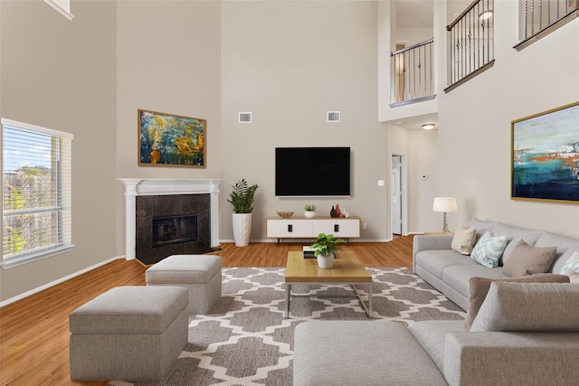 living room featuring light wood-type flooring and a high ceiling