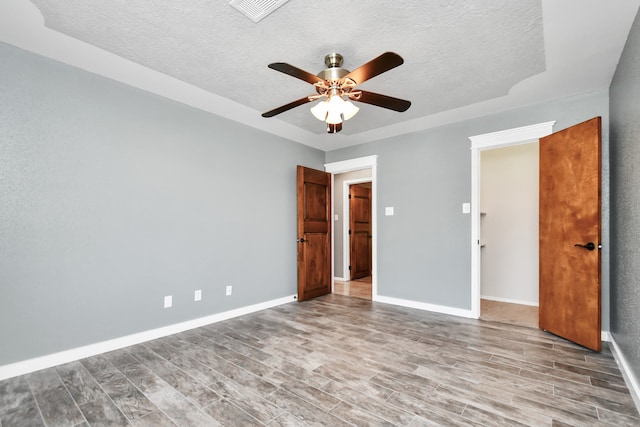 unfurnished bedroom featuring a textured ceiling, light wood-type flooring, and ceiling fan