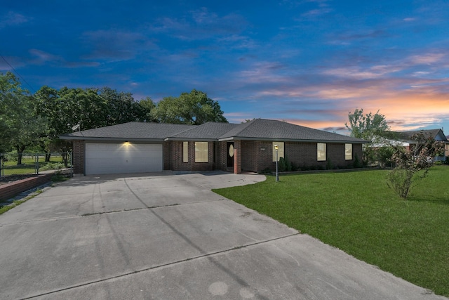 ranch-style home featuring a yard and a garage