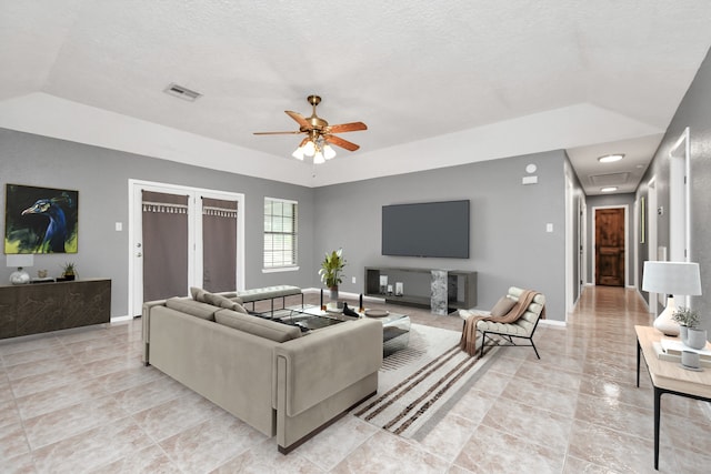 living room with ceiling fan, lofted ceiling, and light tile patterned floors