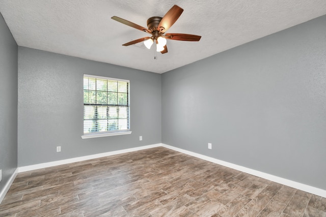 spare room with ceiling fan, a textured ceiling, and hardwood / wood-style flooring