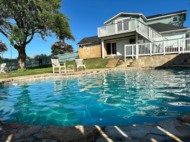 view of pool with a fenced in pool, fence, and stairway