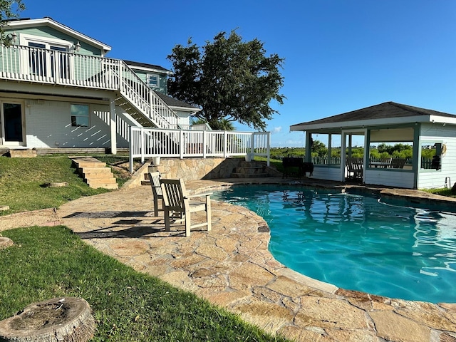 outdoor pool featuring a wooden deck and stairs