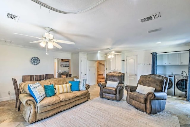 living area with ornamental molding, washing machine and dryer, visible vents, and a ceiling fan