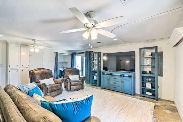 living area featuring stone finish floor, ceiling fan, and baseboards