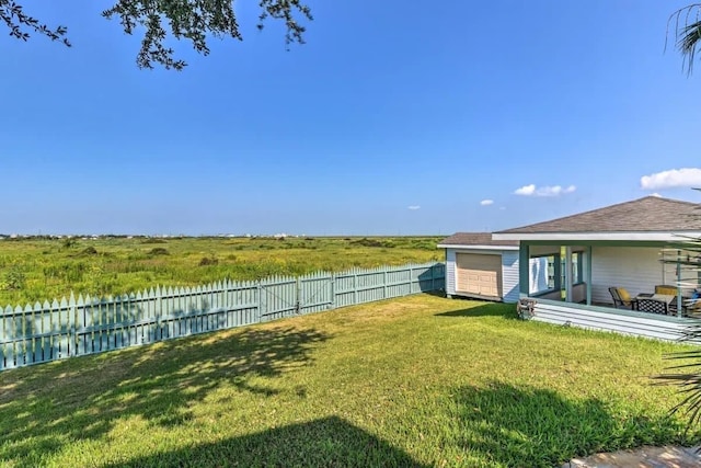 view of yard with a water view and a fenced backyard