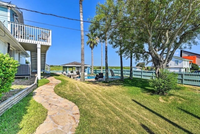 view of yard featuring stairs, fence, a fenced in pool, and a gazebo