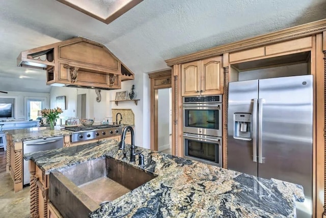 kitchen featuring stainless steel appliances, a sink, vaulted ceiling, open shelves, and dark stone countertops