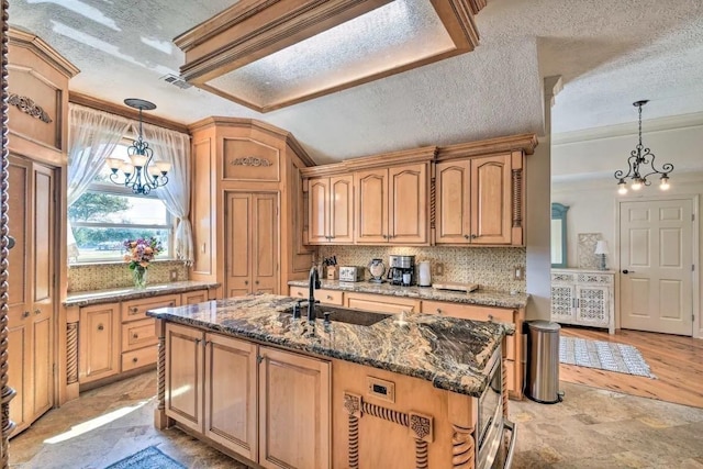 kitchen with decorative light fixtures, a notable chandelier, visible vents, an island with sink, and dark stone counters