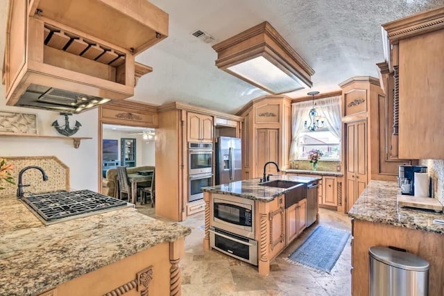 kitchen with visible vents, stainless steel appliances, dark stone counters, and a center island with sink