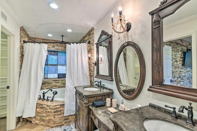 bathroom with two vanities, a sink, a bathing tub, and crown molding