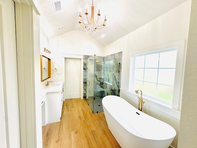 bathroom featuring separate shower and tub, vanity, wood-type flooring, vaulted ceiling, and a chandelier