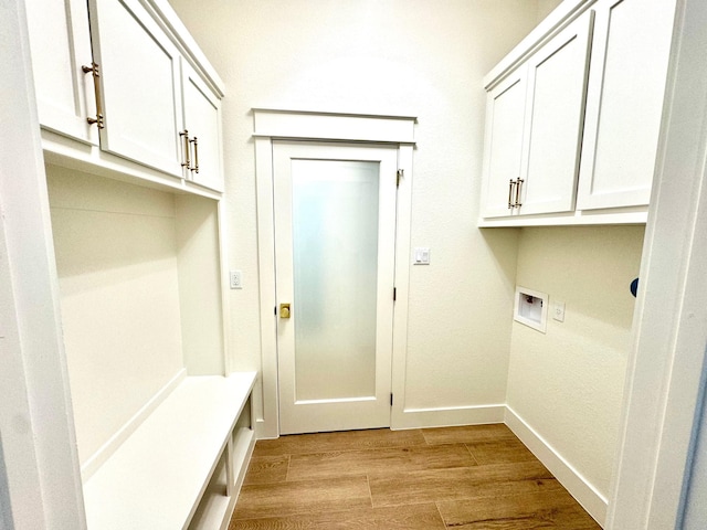 washroom with cabinets, washer hookup, and light hardwood / wood-style flooring