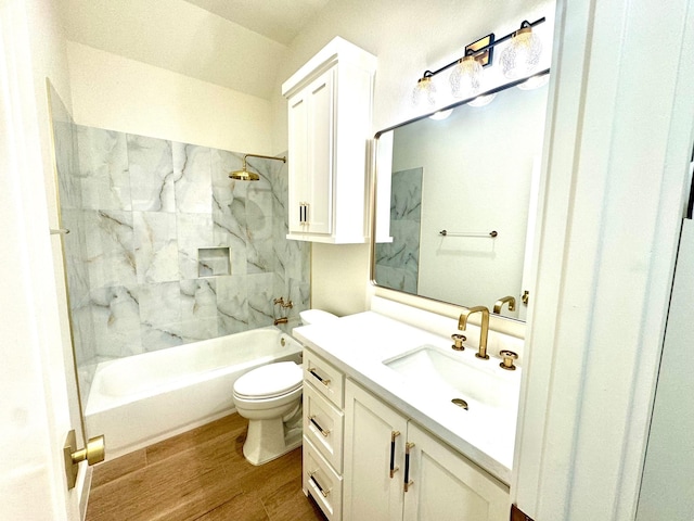 full bathroom with hardwood / wood-style flooring, tiled shower / bath, vanity, and toilet