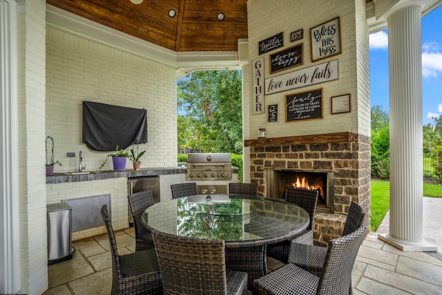 view of patio with exterior kitchen and a grill