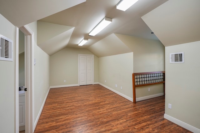 bonus room featuring vaulted ceiling and dark wood-type flooring