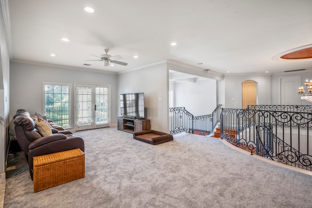 interior space featuring ceiling fan with notable chandelier and crown molding