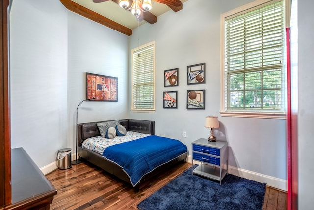 bedroom featuring ceiling fan, multiple windows, and dark wood-type flooring