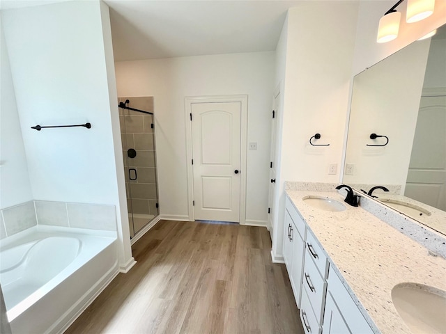 726 Blue Stone Dr, Beasley, TX 77417 - full bathroom with double vanity, wood finished floors, a garden tub, and a stall shower
