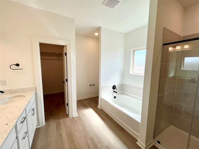 726 Blue Stone Dr, Beasley, TX 77417 - bathroom with a spacious closet, wood finished floors, a garden tub, and a shower stall