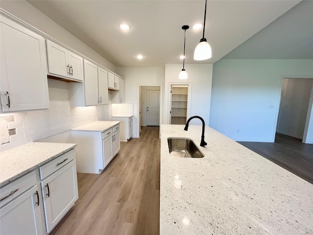 726 Blue Stone Dr, Beasley, TX 77417 - kitchen featuring light stone counters, tasteful backsplash, light wood-type flooring, white cabinetry, and recessed lighting