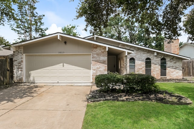 ranch-style house with a garage and a front yard