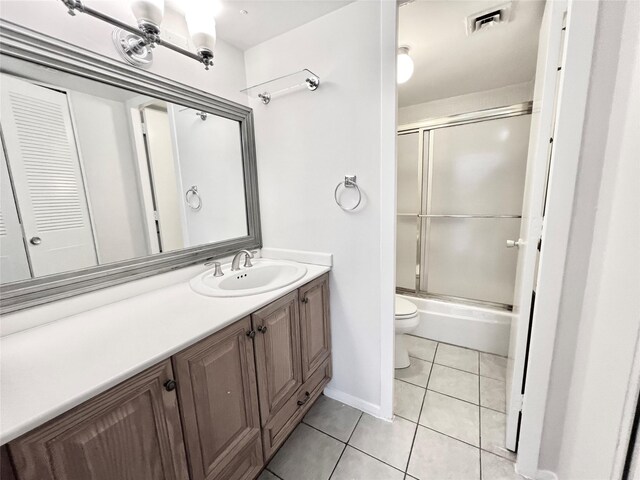 full bathroom with vanity, toilet, tile patterned flooring, and bath / shower combo with glass door