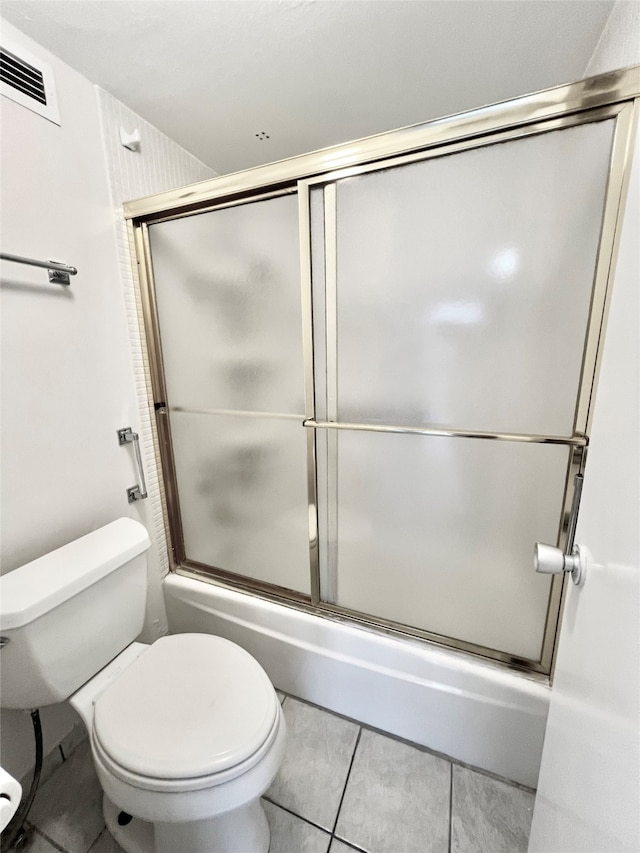 bathroom with enclosed tub / shower combo, toilet, and tile patterned flooring