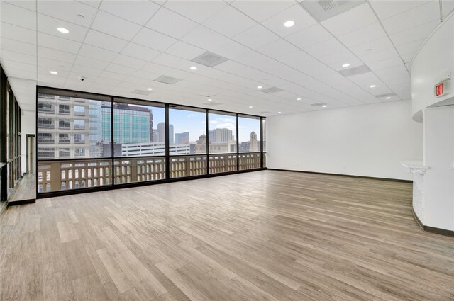 spare room with expansive windows and light wood-type flooring