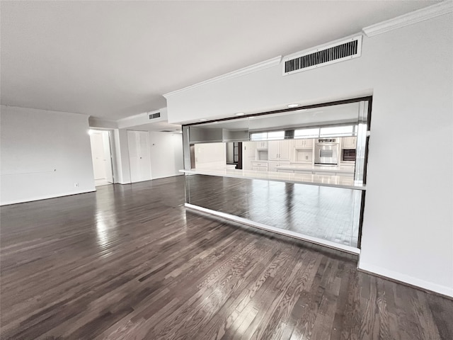 unfurnished living room with ornamental molding and dark wood-type flooring