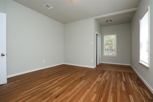 spare room featuring a wealth of natural light and hardwood / wood-style floors