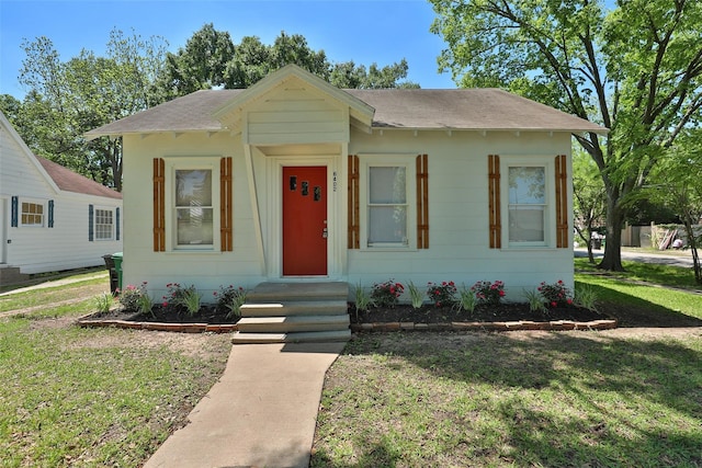 bungalow-style house featuring a front lawn