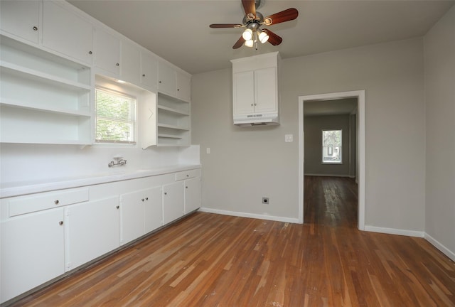 kitchen with ceiling fan, wood-type flooring, and white cabinets