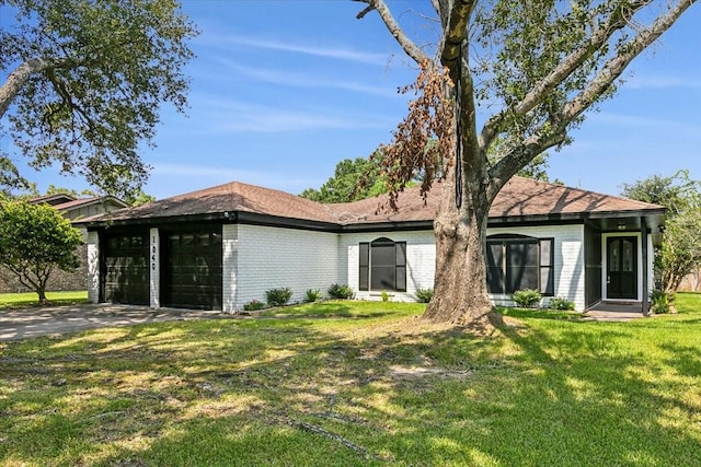 view of front of house with an attached garage, a front lawn, concrete driveway, and brick siding