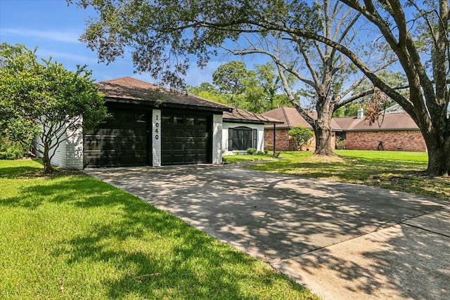 single story home with a front yard, driveway, and an attached garage