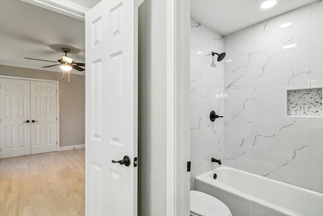 bathroom featuring toilet, a ceiling fan, wood finished floors, and shower / bathtub combination