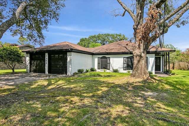 exterior space featuring a garage, concrete driveway, a front lawn, and brick siding