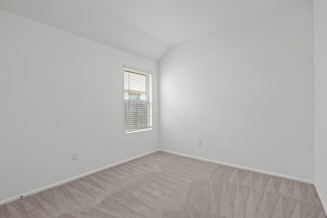 spare room featuring lofted ceiling and carpet flooring