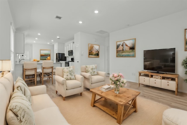 living room with sink and light hardwood / wood-style floors