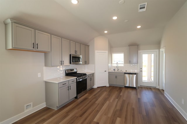 kitchen featuring sink, vaulted ceiling, stainless steel appliances, and gray cabinets