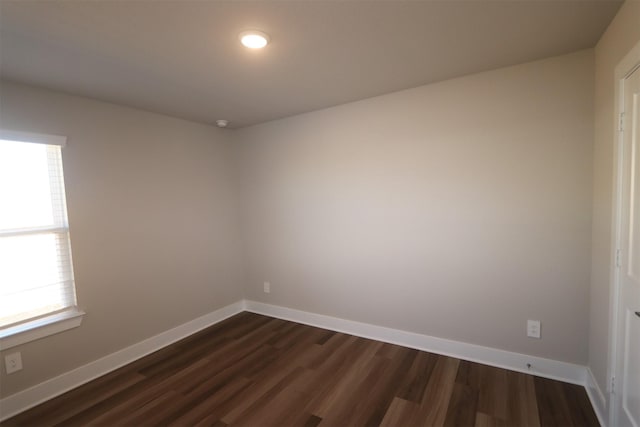 spare room with dark hardwood / wood-style floors and a wealth of natural light