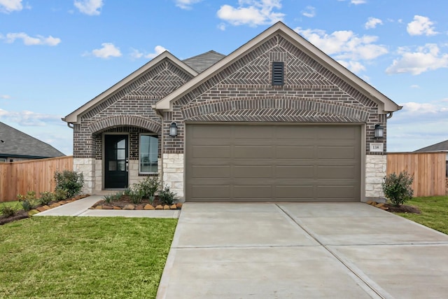 french country style house with brick siding, an attached garage, fence, stone siding, and driveway