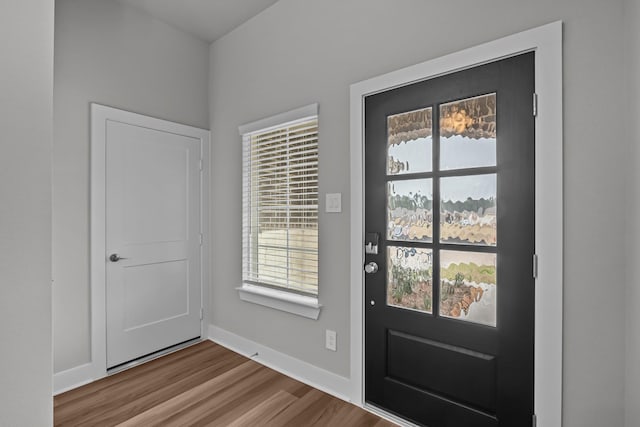 doorway to outside with baseboards and wood finished floors