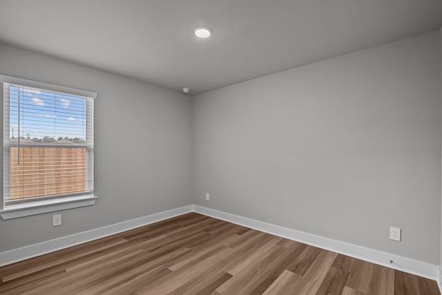 unfurnished room with baseboards and wood finished floors