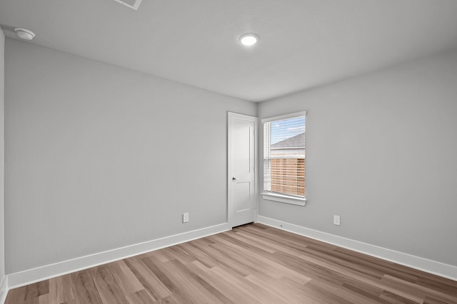 empty room featuring light wood-type flooring and baseboards