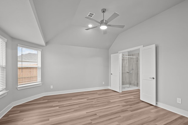 unfurnished bedroom with light wood-style flooring, visible vents, vaulted ceiling, and baseboards