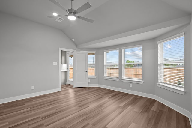 unfurnished bedroom featuring lofted ceiling, wood finished floors, visible vents, and baseboards