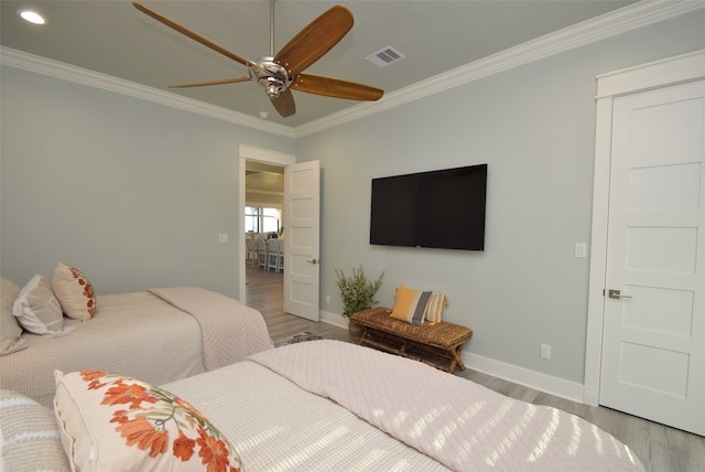 bedroom featuring ceiling fan, hardwood / wood-style floors, and crown molding