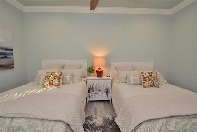 bedroom featuring wood-type flooring, ornamental molding, and ceiling fan