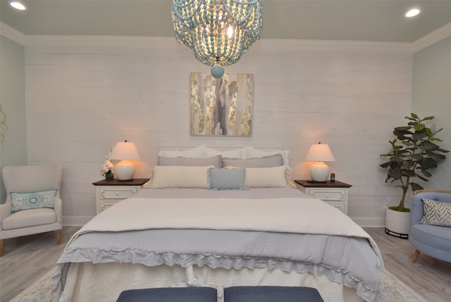 bedroom with ornamental molding, light hardwood / wood-style flooring, and a chandelier